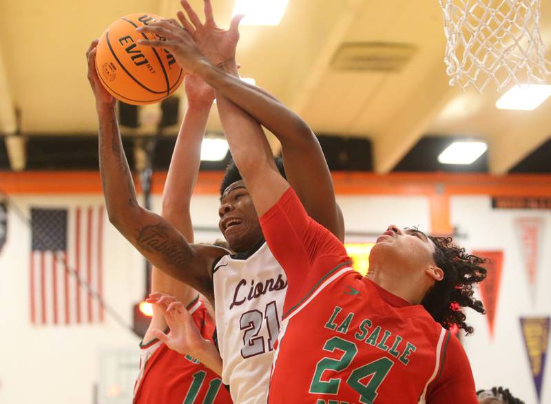 Peoria's LeShawn Stowers grabs a rebound over L-P's Marion Persich during the Class 3A Sectional semifinal game on Wednesday, March 5, 2025 at Washington High School.