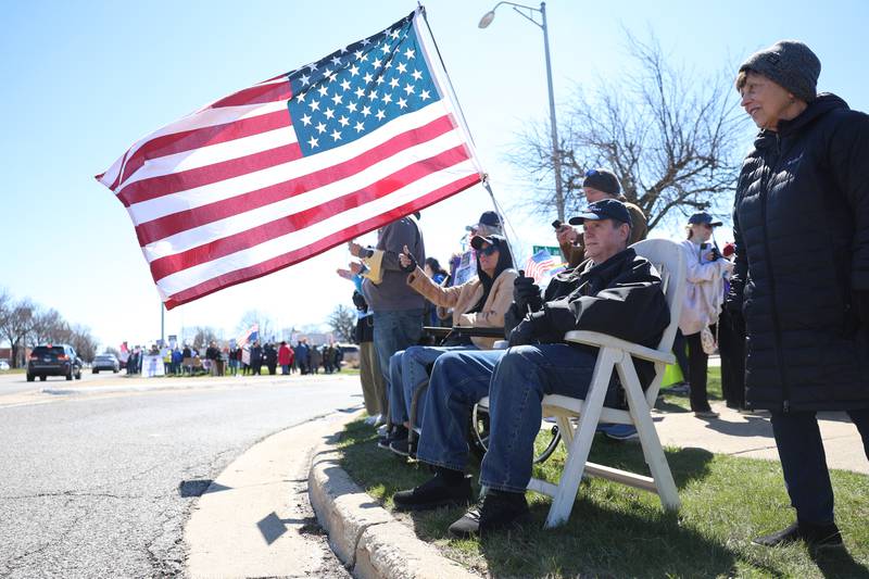 Bob Schmitt holds an American flag along Plainfield Road at the No Kings rally on Saturday, March 28, 2026 in Joliet.
