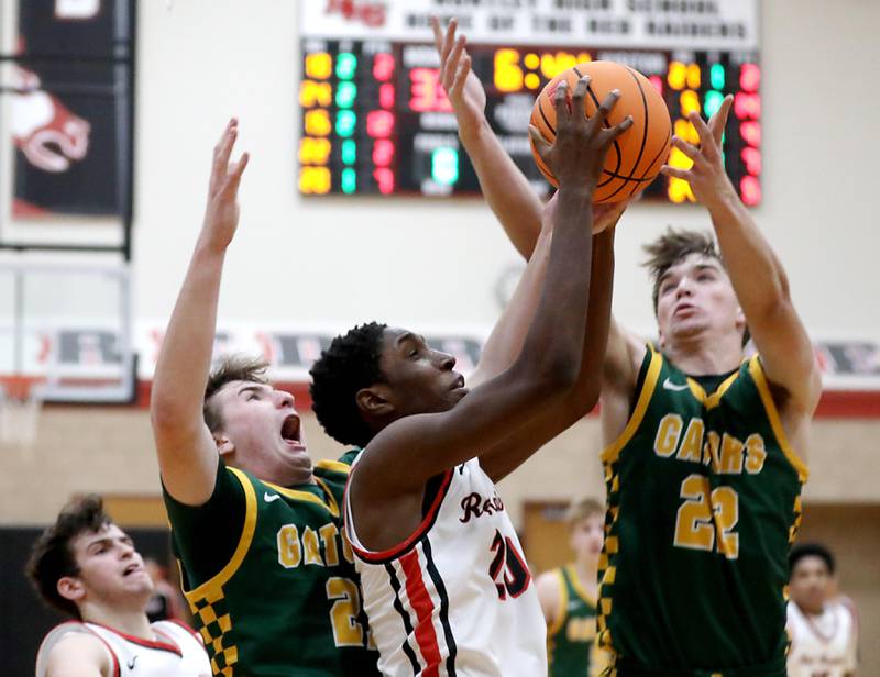Huntley's Isaiah Onu grabs a rebound between Crystal Lake South's Ryan Morgan (left) and Nick Stowasser (right) during a Fox Valley Conference boys basketball game on Wednesday, Dec. 10, 2025, at Huntley High School.
