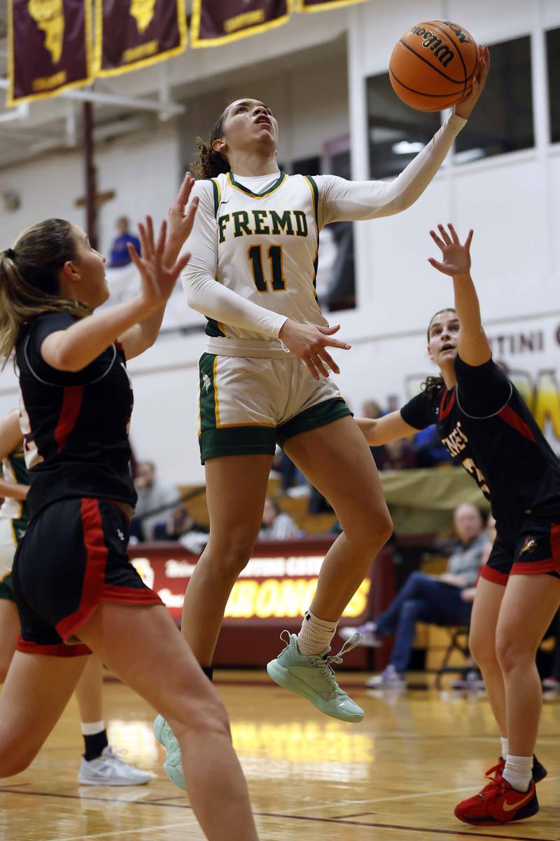 Fremd’s Coco Urlacher (11) drives to the hoop as she splits two Benet Academy players during the Montini girls basketball Christmas tournament Saturday, Dec. 28, 2024 in Lombard.