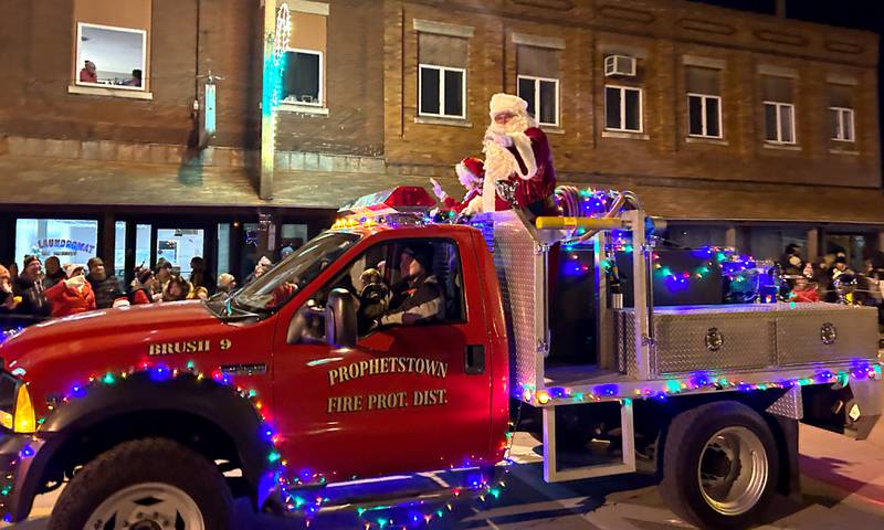 Santa Claus waves to the crowd from the back of a firetruck at the Prophetstown Proud's 38th Lighted Christmas Parade on Saturday, Nov. 25.