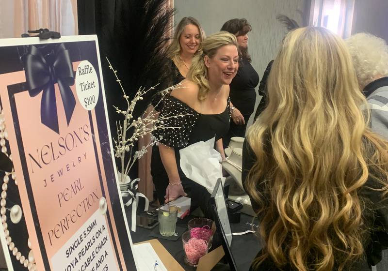 Katie Caven, center, owner of Nelson's Jewelry in Crystal Lake, interacts with attendees at CASA of McHenry County's Little Black Dress celebration and fundraiser Oct. 10, 2024.