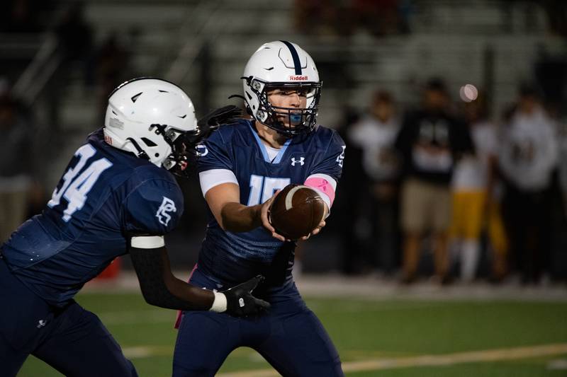 Plainfield South's Cody Hogan hands off the ball to Prentice Smith during a game against Joliet West Friday Oct. 4, 2024 at Plainfield South High School