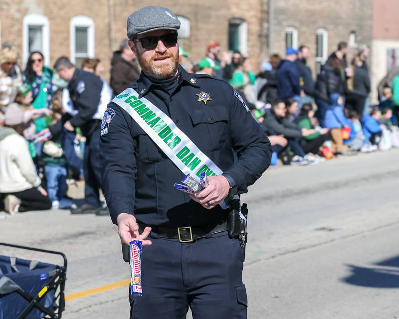 Police Commander Dan Dykshorin throws out candy in the Lemont St. Pat's Day Parade on Saturday, March 8, 2025  in Lemont.
