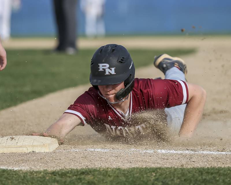 Plainfield North's Gavin Person (7) dives back to first on a pick off attempt during baseball game between Plainfield North at Oswego, Thursday, April 24, 2025 in Oswego.