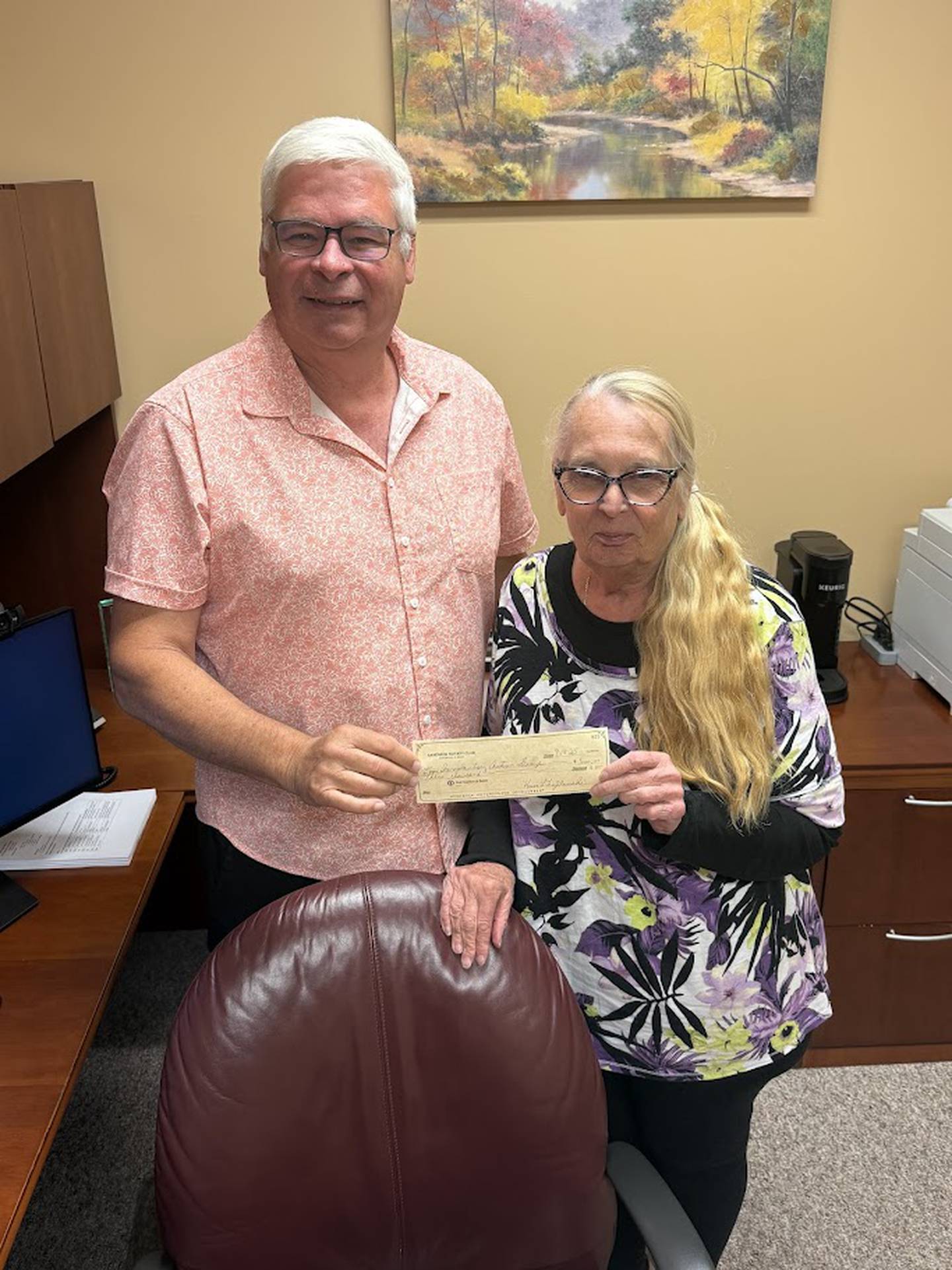 Voluntary Action Center Executive Director Nate Kloster (left) receives a donation check from Karen Tryblowski of the Sandwich Rotary Club to assist the Sandwich Meals on Wheels program with the lease of a heat sealer for the meals.