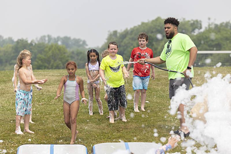 Dre Jackson hoses down campers Thursday, June 15, 2023 during Dixon Park District’s SPARK Camp.