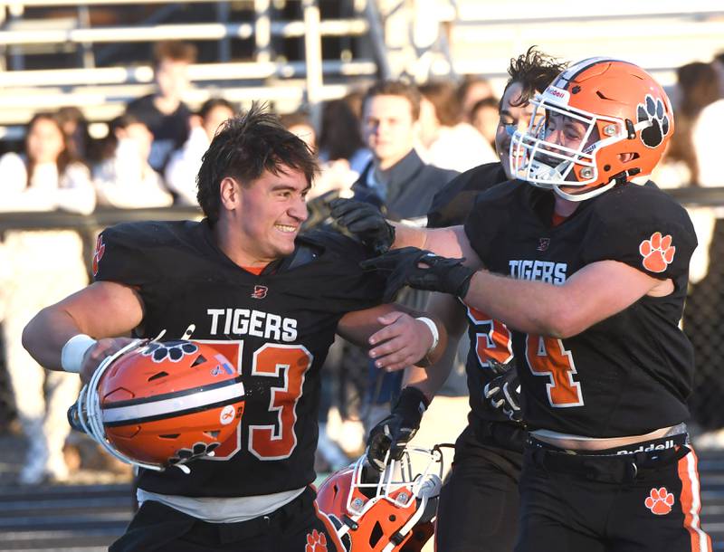 Byron linemen Dalton Norris (53), Dawson Criddle (4), and Braiden Hammes (54) celebrate after the Tiger's 28-6 win over Elmhurst IC Catholic in 3A quarterfinal action at Byron High School on Saturday, Nov. 15, 2025.