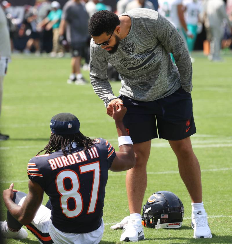 Chicago Bears quarterback Caleb Williams talks to wide receiver Luther Burden III as he stretches Sunday, Aug. 10, 2025, before their preseason game against the Miami Dolphins at Soldier Field in Chicago.