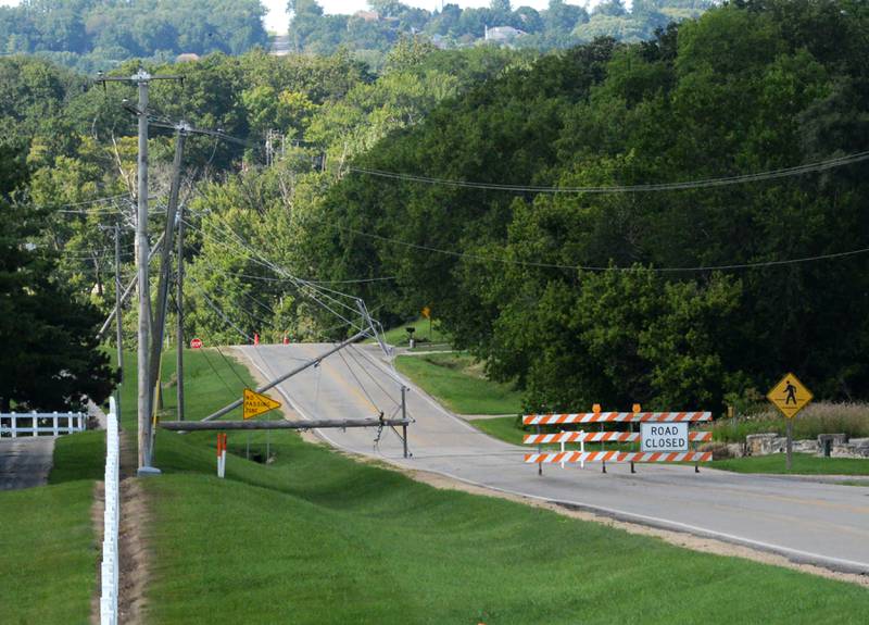 A portion of German Church Road, south of Byron, was closed Wednesday, July 17, 2024 when Monday's storm caused  utility poles to fall. ComEd crews were still working to restore power to rural areas affected by the storm.