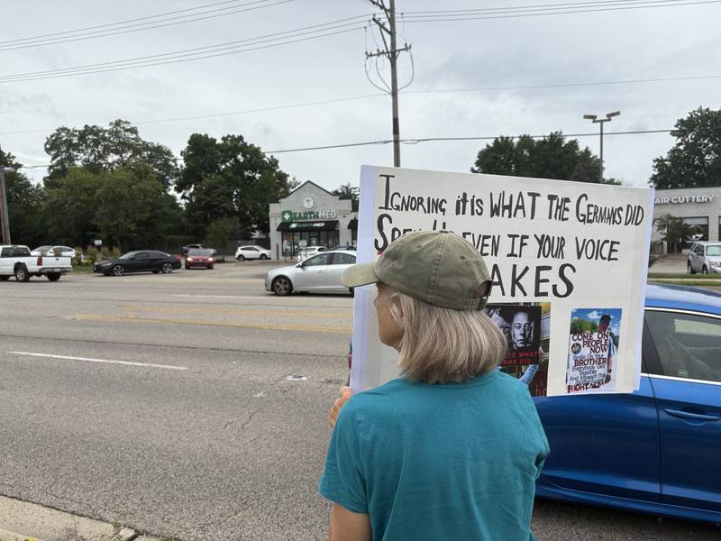 Pat Irvin holds a sign during a protest against President Trump July 26, 2025 in McHenry.