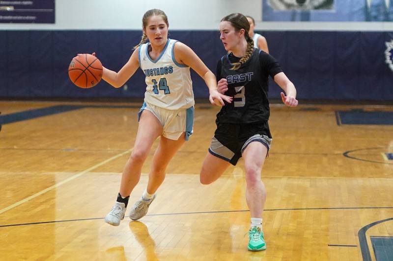 Downers Grove South's Allison Jarvis (14) drives to the basket against Oswego East's Maggie Lewandowski (3) during a 4A Oswego East Regional semifinal girls basketball game at Oswego East High School on Monday, Feb 12, 2024.