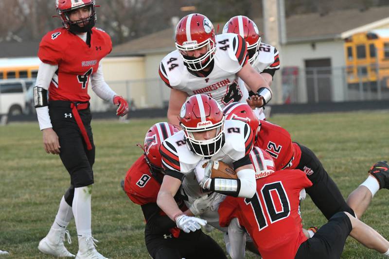 Forreston's Matthew Beltran dives in for a score as Amboy's Trevor Vaessen, Caden Wittenauer, and Jordan Gulley converge on the tackle.