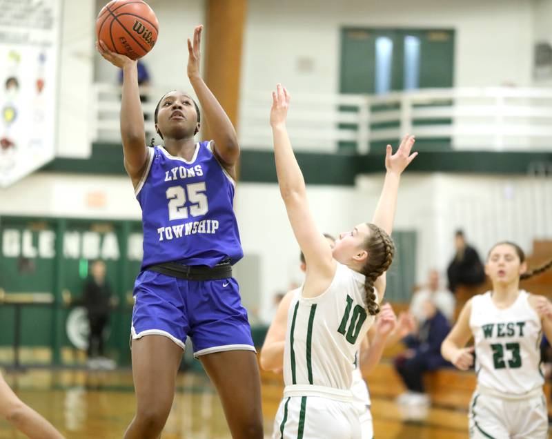 Lyons Township’s Nora Ezike (left) shoots the ball over Glenbard West’s Julia Benjamin during a game in Glen Ellyn on Tuesday, Dec. 12, 2023.