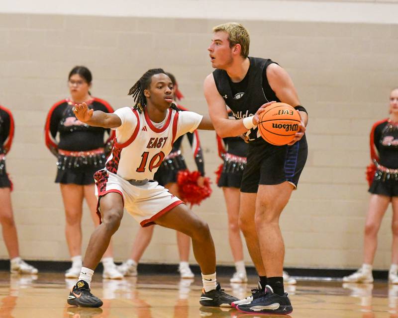 Glenbard East's Cameron Bonner (10) defends Riverside Brookfield's Benjamin Biskupic (22) as he looks for an open teammate during the game on Friday Dec. 19, 2025, held at Glenbard East High School.