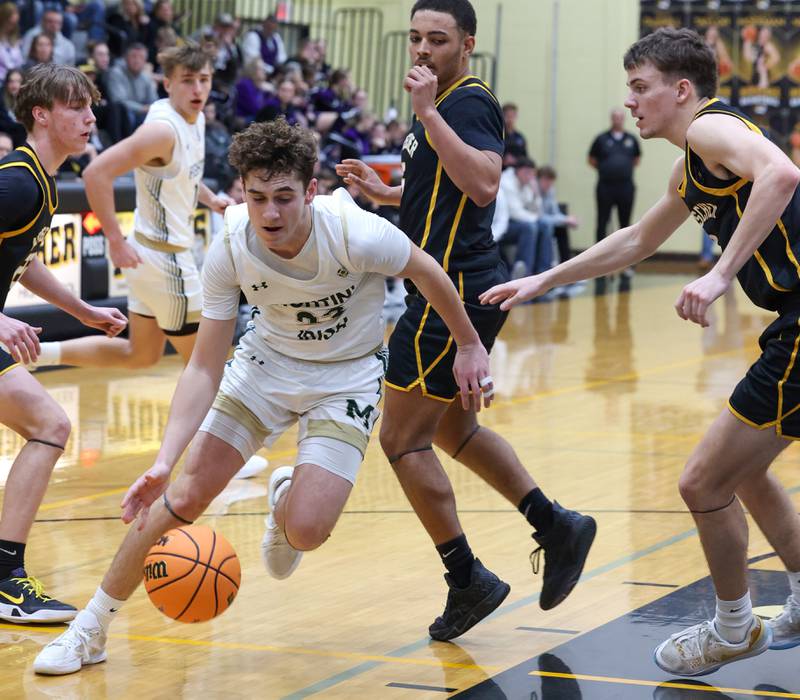 Bishop McNamara's Karter Krutsinger drives to the lane through Herscher defenders during Bishop McNamara's 71-42 victory in the IHSA Class 2A Herscher Regional semifinal on Wednesday, Feb. 25, 2026.