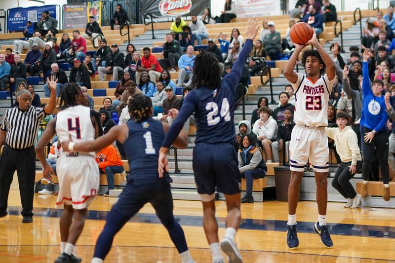 Oswego’s Dasean Patton (23) shoots a three pointer against Rockford Guilford during a hoops for healing basketball tournament game at Oswego on Monday, Nov. 25, 2024.