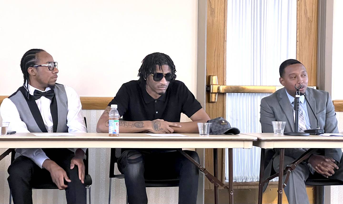 Malcom Turner, left, and Diasee Scott, middle, sit at a table in the Sky Room of NIU's Holmes Student Center on Feb. 16, 2023, as St. Anthony Lloyd, right, talks about Project Flex transforms the mindsets of incarcerated youth in Illinois.