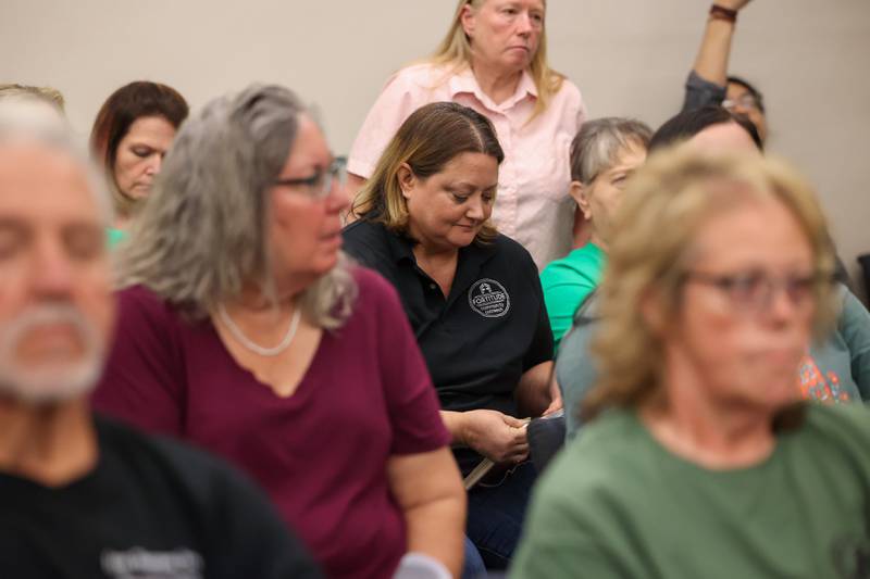 Surrounded by Fortitude Community Outreach supporters, executive director Dawn Broers gathers her notebook as the request for a conditional use permit to allow Fortitude to operate a shelter at 970 E. Court St. in Kankakee was rejected by a 12-0 vote at the Kankakee City Council meeting on Monday, Sept. 15, 2025.