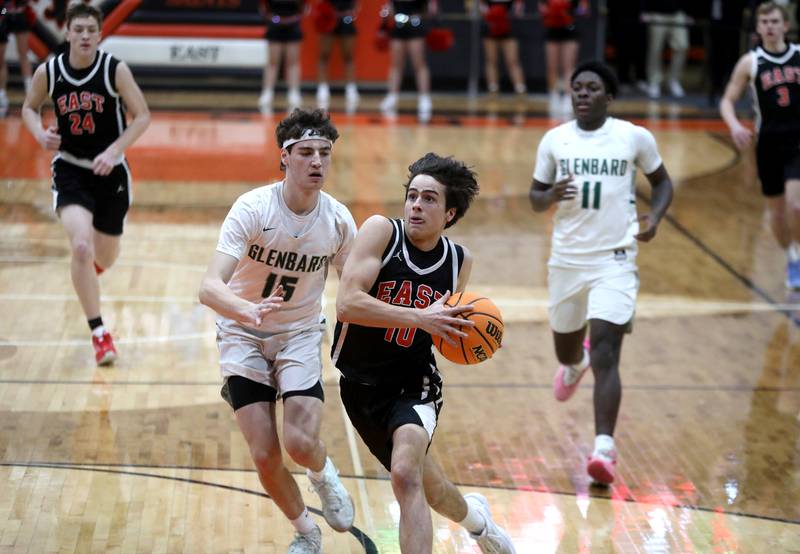 Glenbard East's Devin Kraft goes to the basket trailed by Glenbard West's Drew Gacek during a Class 4A St. Charles East Sectional semifinal on Tuesday, March 4, 2025 in St. Charles.