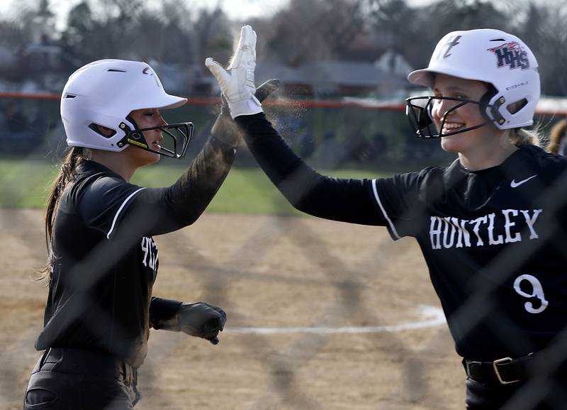 Huntley's Piper Heimbrodt high fives her teammate, Cecilia Romano, after scoring a run during a Fox Valley Conference softball game on April 7, 2026, at Crystal Lake Central High School.