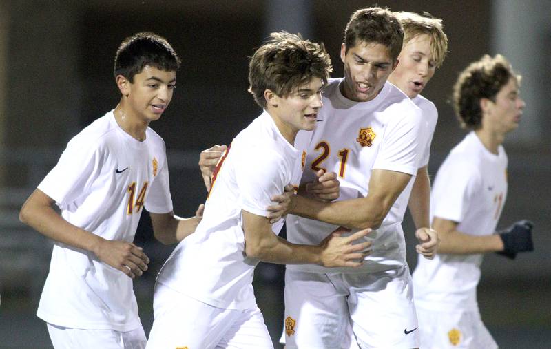 Richmond-Burton’s Nick Kyes, front center, is greeted by Aidan Albert and others after scoring in varsity soccer on Monday, Oct. 7, 2024, at Dan Horne Field on the campus of Harvard High School in Harvard.
