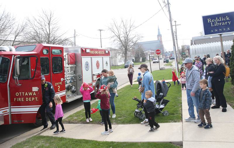 Kids wait their turn to climb into a Ottawa fire engine during story time on Thursday, April 10, 2025 at the Reddick Library in Ottawa.