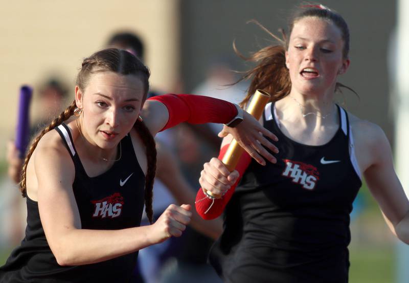 Huntley’s Emily Byers, right, hands off to teammate Addison Busam in the 400-meter relay  in IHSA Class 3A Girls Sectional Track and Field Meet action at Red Raider Stadium on the campus of Huntley High School in Huntley on Wednesday, May 14, 2025.