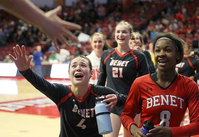 Benet Academy's Peyton Turner (4) Charlotte Torres, (21) and libero Aniya Warren hi-five fans after defeating Barrington in the Class 4A semifinal game on Friday, Nov. 11, 2022 at Redbird Arena in Normal.