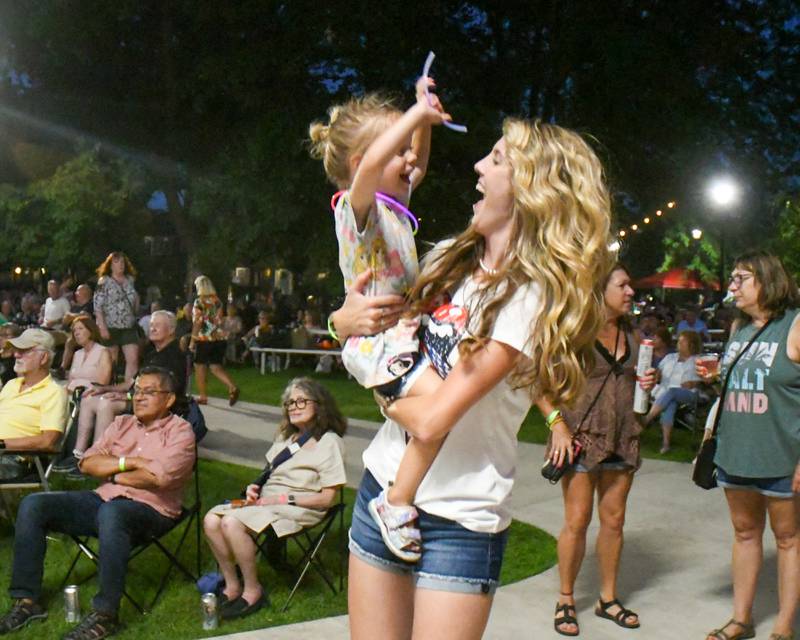 Avery Armburst, 3, and her mom Lauren Armburst of St. Charles dance to the music performed by Rocks Off: A Tribute to The Rolling Stones at Memorial Park in Wheaton on Friday Aug. 2, 2024.