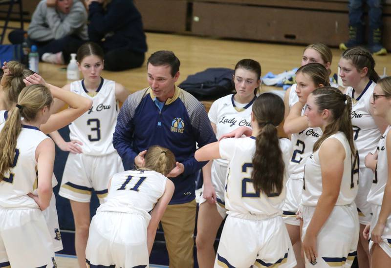 Marquette head girls basketball coach Eric Price huddles with his team during a timeout as the play St. Bede on Monday, Nov. 27, 2023 in Bader Gym at Marquette High School.