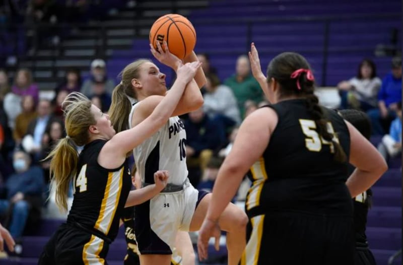Manteno’s Alyssa Singleton elevates for a shot over Herscher’s Elsie Hoffman, left, and Anistin Hackley, right, during Thursday’s game in Manteno.