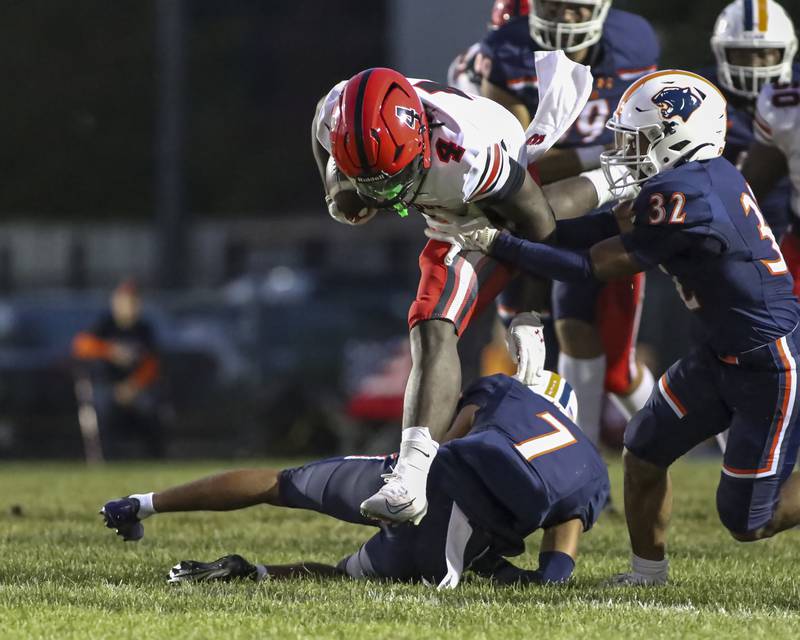 Bolingbrook's Timmie Lewis II (4) leaps over Oswego's Dontrell Young (7) during football game between Bolingbrook at Oswego Friday, Sept 12, 2025  in Oswego.