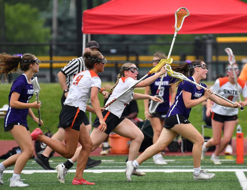 Downers Grove North’s Finley Paul (right) races with the ball while chased by Crystal Lake defenders during the Benet Supersectional game on June 3, 2025 at College of DuPage in Glen Ellyn.