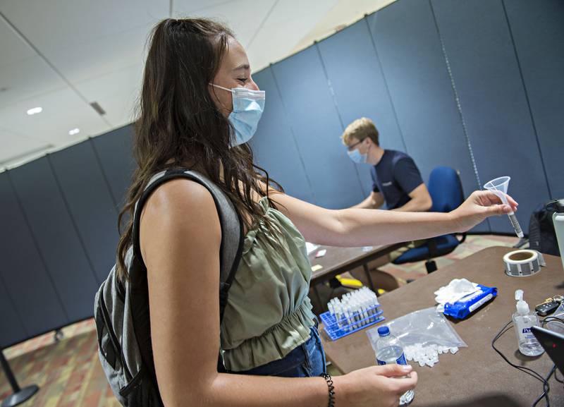 Juliana Rotella of Dixon is handed a funnel and vial Wednesday, August 25, 2021 at Sauk Valley Community College for COVID testing. Unvaccinated students at the school need to be tested once a week. Rotella, who is a student athlete, has had her shot but is required to be tested due to NJCAA regulations.