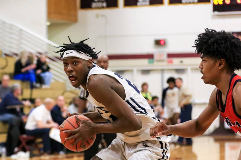 Oswego East's Mekhi Lowery (24) makes a move under the basket during Class 4A Lockport Regional final game between West Aurora at Oswego East.  Feb 24, 2023.