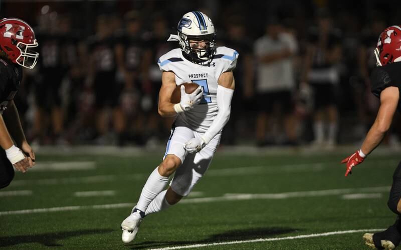 Prospect’s Jake Parisi tries to squeeze through two Maine South defenders in a Thursday night football game in Park Ridge on September 15, 2022.
