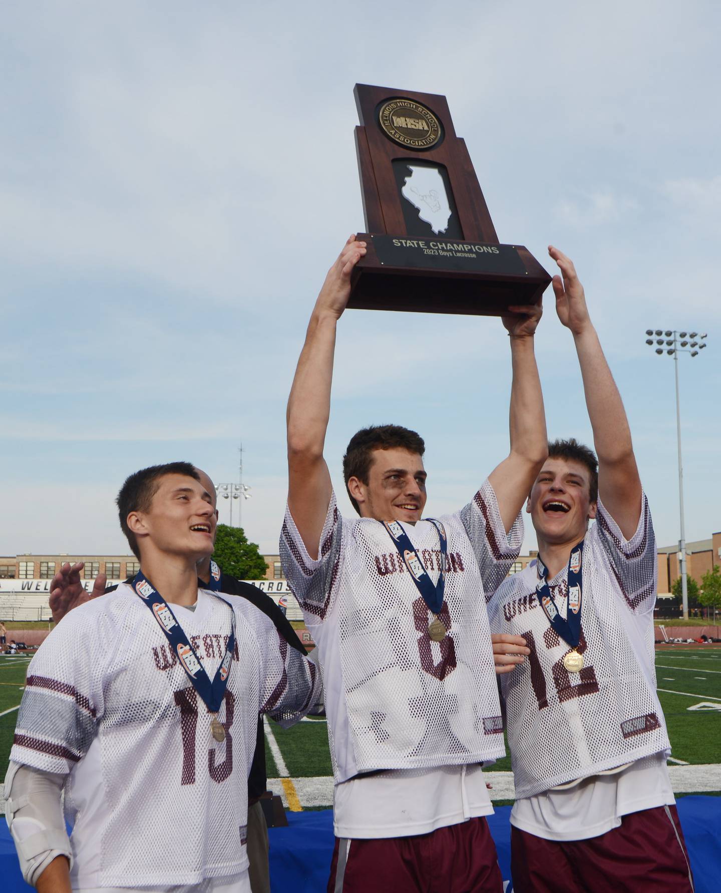 Joe Lewnard/jlewnard@dailyherald.com
Left to right, Wheaton Academy’s Gavin Pedone, Aiden Weisenborn and Jaret Jawor hold their team’s state-championship trophy at the conclusion of the boys state lacrosse championship in Hinsdale Saturday.