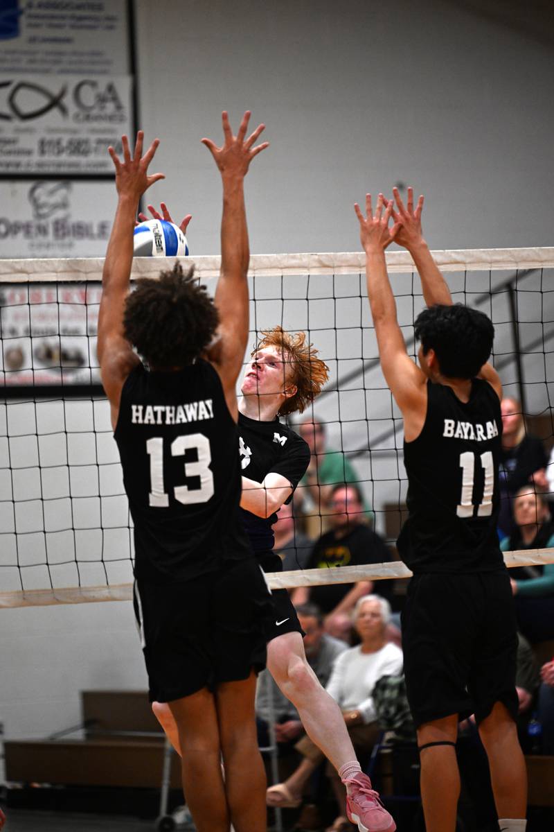 Manteno's Maverick Kenney aims over the net while Kankakee Trinity Academy's Corey Hathaway and Johnny Bayaraa block on Thursday, May 1, 2025.