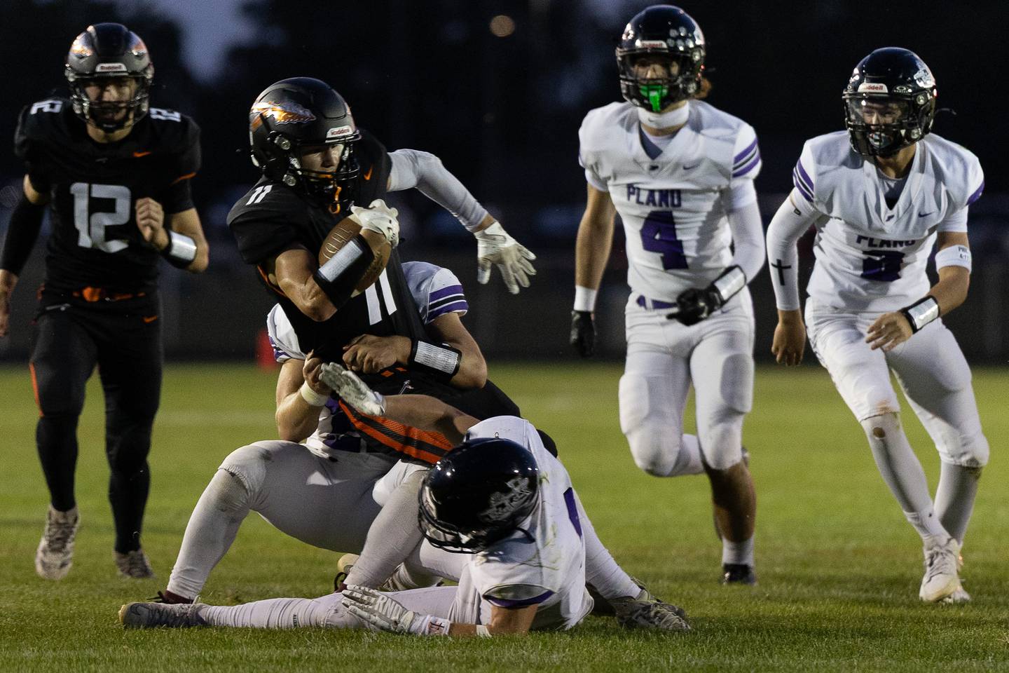Sandwich's Nick Michalek leans forward for more yardage while being brought down by a Plano tackler during Friday's game in Sandwich.