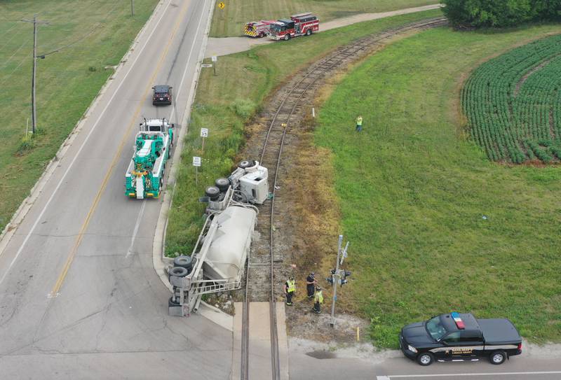 Wallace firefighters work the scene of an overturned sand hauler at the intersection of North 15th Road and U.S. Route 6 on Wednesday, July 9, 2025 in Ottawa. The semi overturned on the train tracks. La Salle County Sheriff and Ottawa Police assisted with the crash.