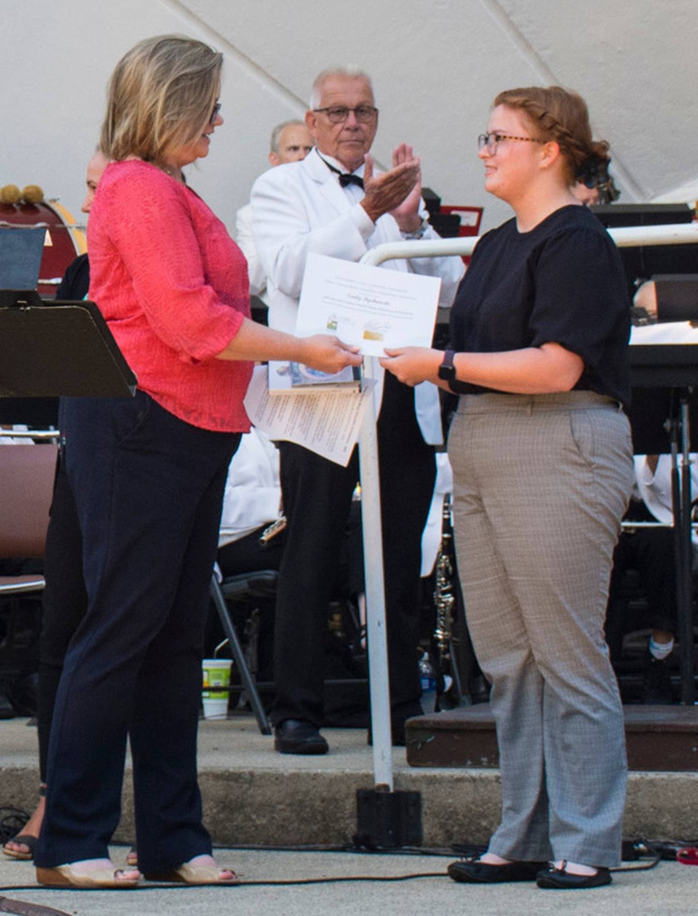 Emily Bychowski receiving a scholarship award certificate at a DeKalb Municipal Band concert