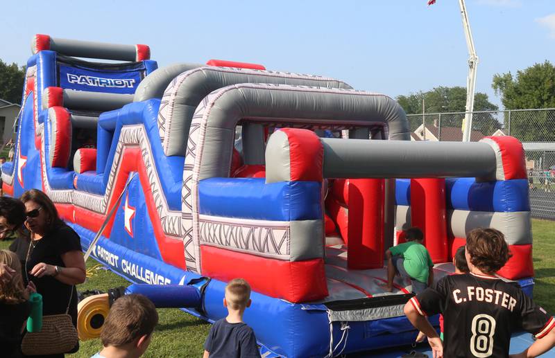 Kids wait in line to jump on a large bounce house during the National Night Out event on Tuesday, Aug. 5, 2025 at Kirby Park in Spring Valley. The event featured prizes, dodge ball tournament, bounce house, face painting and more. National Night Out is an annual community policing campaign held on the first Tuesday of August to create police-community partnerships and build safer neighborhoods.
