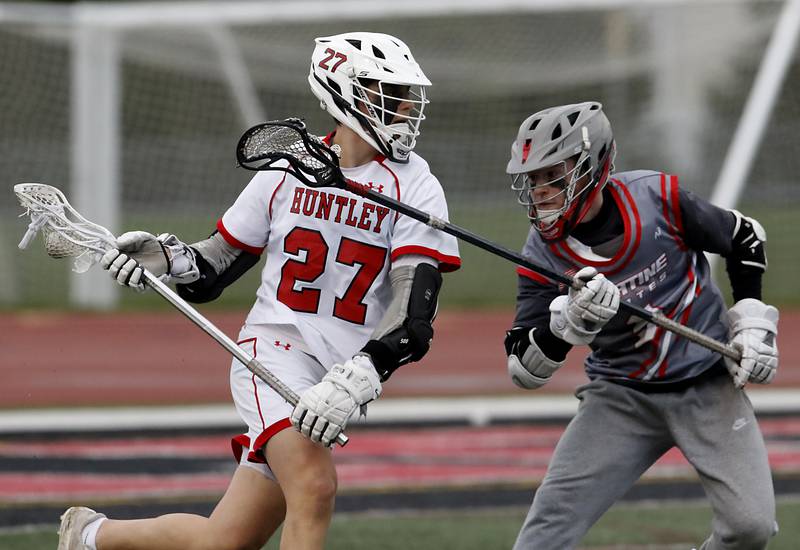 Huntley's Nico Andrews tries to run move against Palatine's Austin Cortez during a boys lacrosse match Tuesday, May 3, 2022, between Huntley and Palatine at Huntley High School.