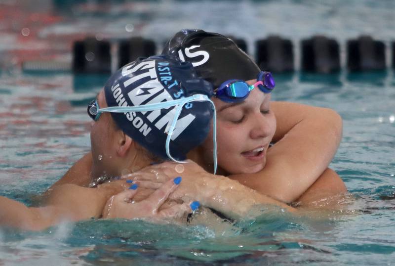Rachel Johnson of Dundee-Crown co-op embraces Abigail Uhr of Crystal Lake South co-op after the 400-yard freestyle relay during the Fox Valley Conference Championship Meet at Woodstock North High School on Saturday, Nov. 2, 2024 in Woodstock .