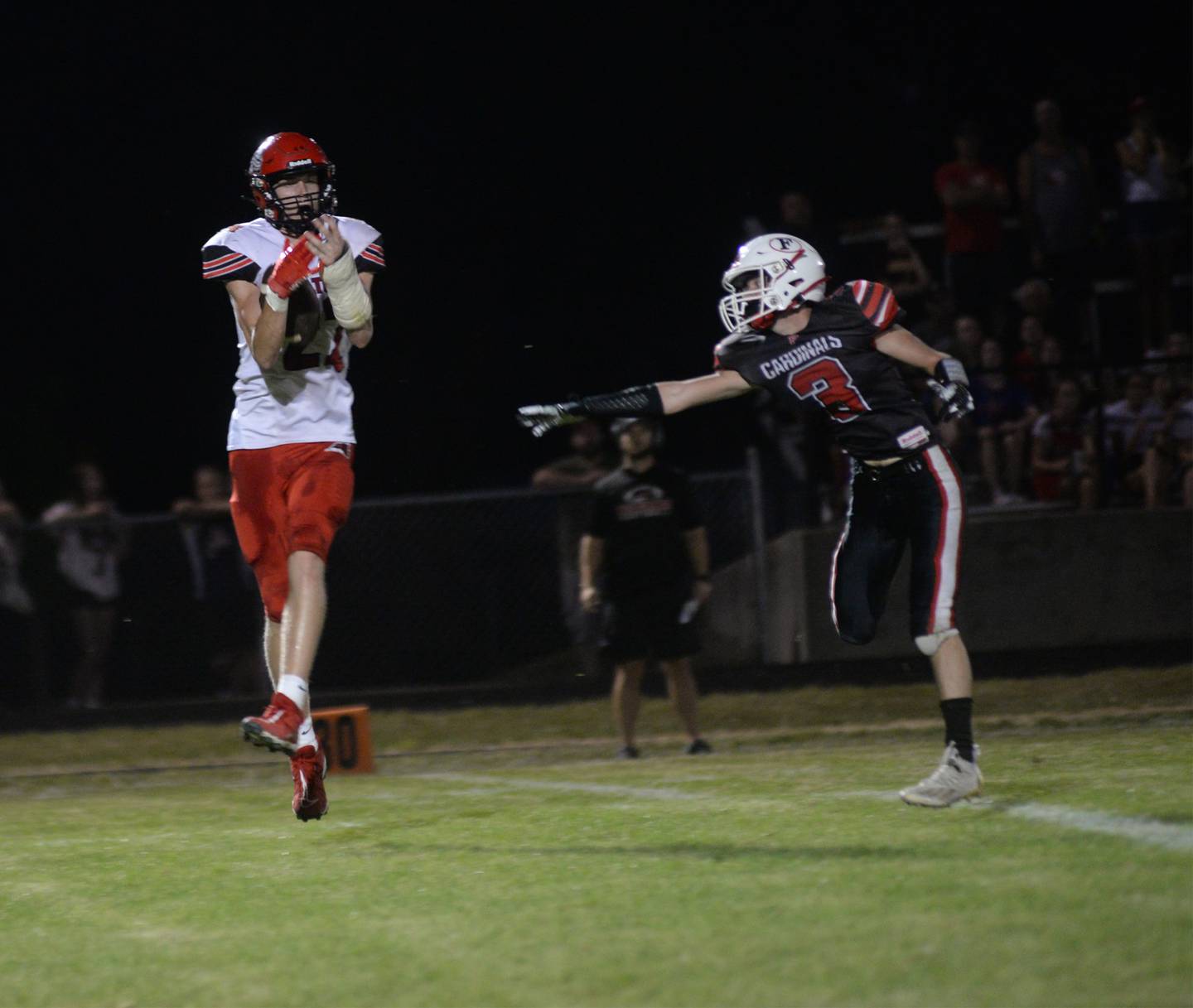 Fulton's Baylen Damhoff (22) catches a pass ove Forreston's Alex Ryi (3) en route to the end zone during on Friday, Aug. 25, 2023.