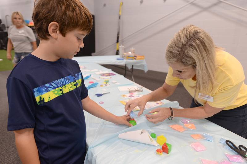 Glen Ellyn Park District employee Michelle Metz helps children including Victor DeAngelo of Glen Ellyn make ounce balls during their unplug from technology Saturday July 13, 2024.