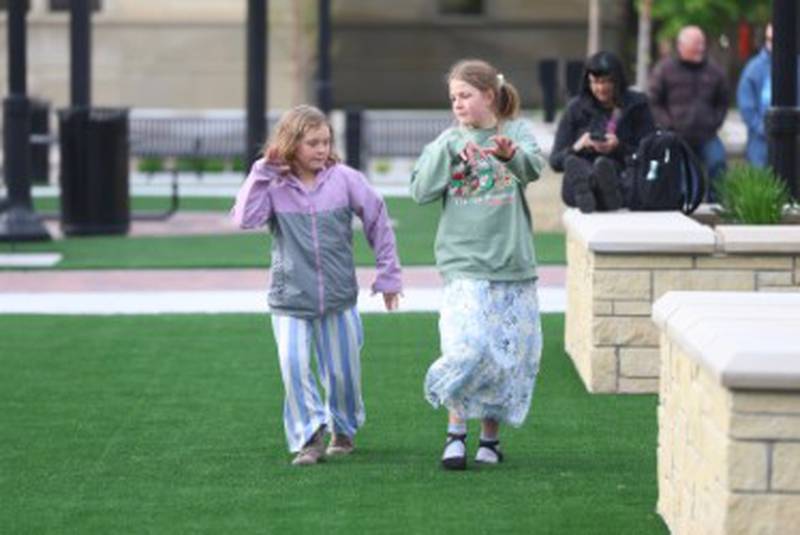 Nine-year-old Emma Tragesser (left) and 12-year-old Grace Tragesser of Naperville take a stroll around the new City Square in downtown Joliet on Friday, May 1, 2026.