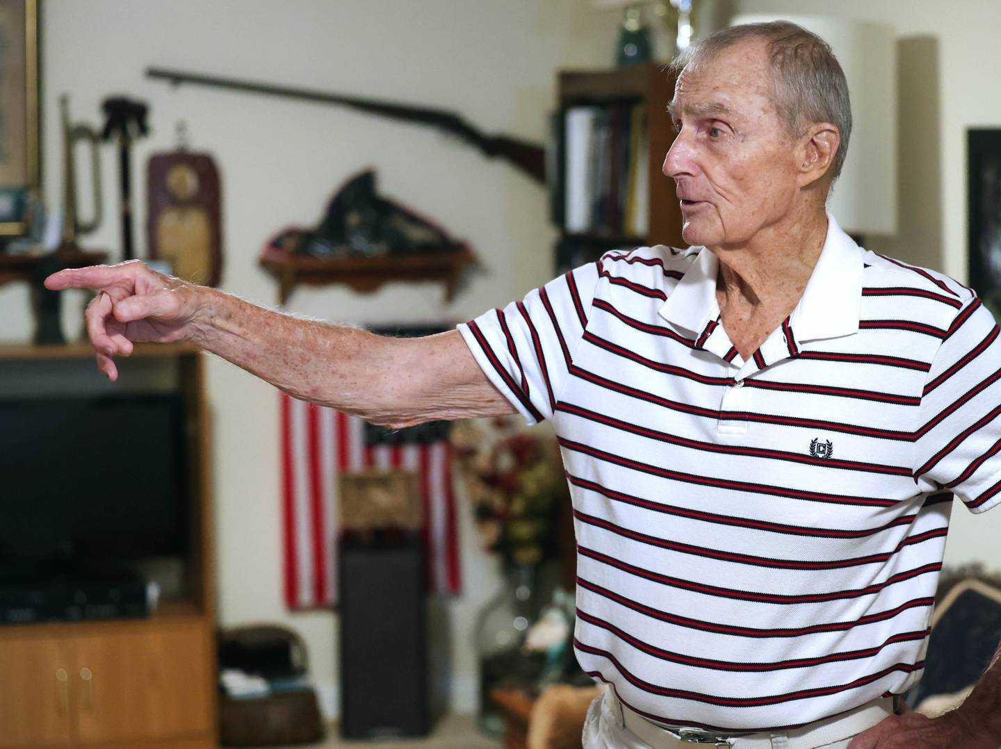 U.S. Army Veteran Jerry Busby talks Wednesday, Aug. 28, 2024, about some of the military and law enforcement memorabilia he has collected over the years that adorn the walls of his DeKalb home.