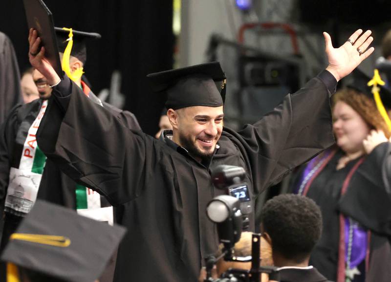 A Northern Illinois University graduate celebrates after receiving his diploma during the first of two undergraduate commencement ceremonies Saturday, May 11, 2024, in the Convocation Center at NIU in DeKalb.